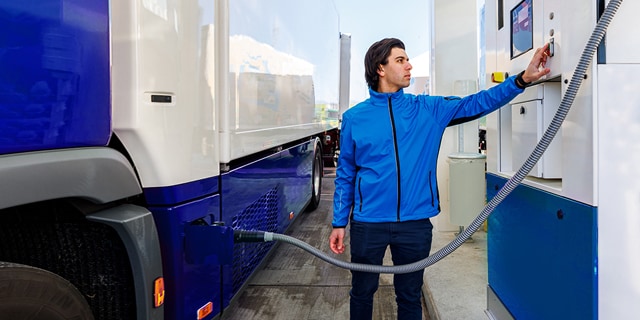Man refueling a heavy-duty hydrogen fuel cell truck 